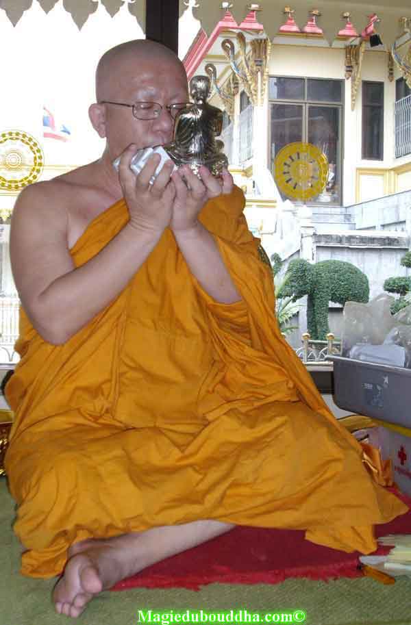 Moine thai qui bénit des amulettes.