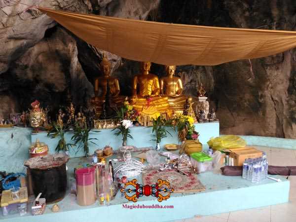 Offrandes au Bouddha dans une grotte sacrée thai.