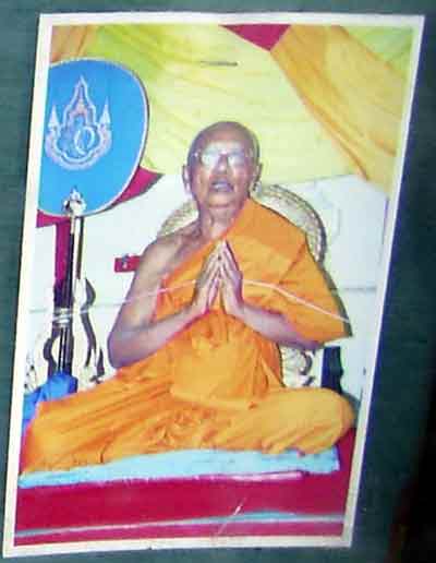 Luang phor happ en train de bénir des amulettes.