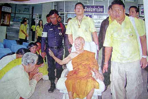 Luang phor koon en fauteuil roulant.